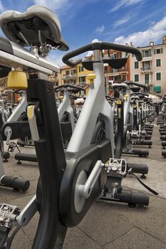 Large group of aluminum exercise bikes outdoors