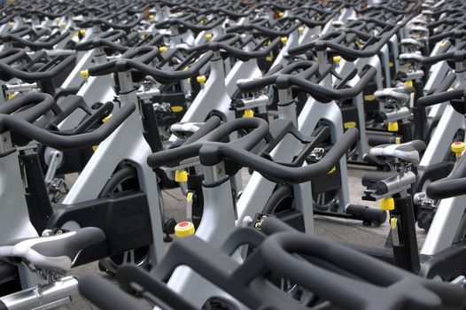 Large group of aluminum exercise bikes outdoors