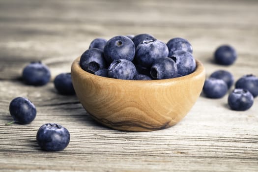 bowl of blueberries on wooden background