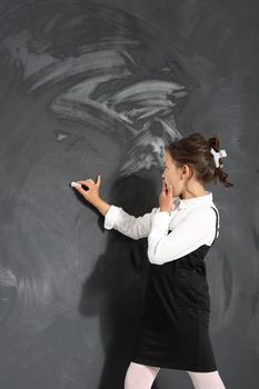 schoolgirl writes on the blackboard .