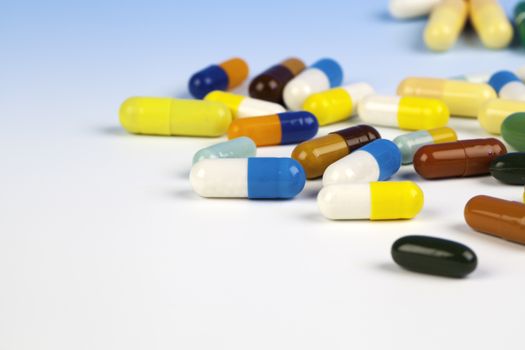 Colorful medical capsules on white background.