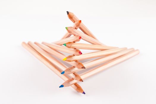 creatively stacked pencils of different colors on white