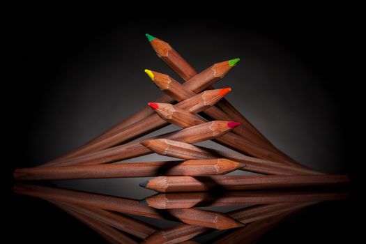 creatively stacked pencils of different colors with backlight