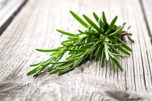 Twigs of rosemary on wooden texture