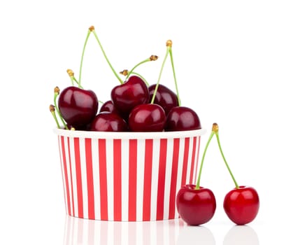 fresh cherry berries in striped bucket on white background