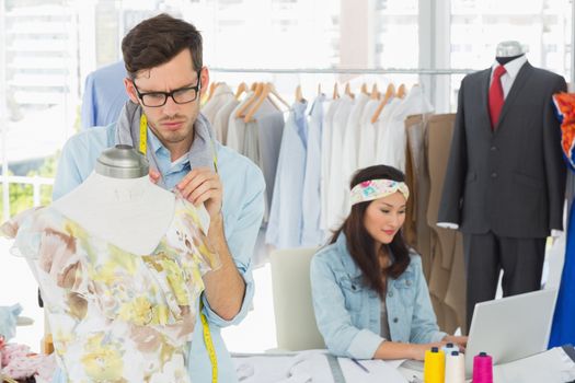 Male and female fashion designers at work in a studio