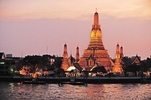 Wat Arun, The Temple of Dawn, at twilight, view across Chao Phraya river. Bangkok, Thailand.