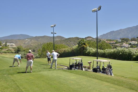 Gof players prepared to strike at the tee in La Quinta golf, a golf course in Marbella, Spain.