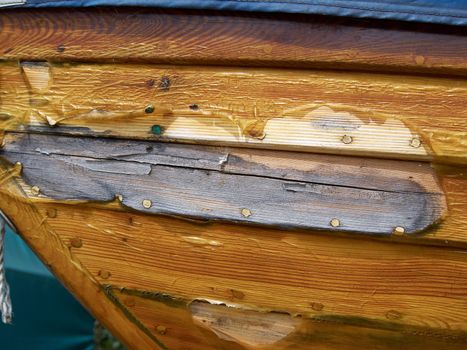 Prow of a small wooden boat with clear blue sky background 