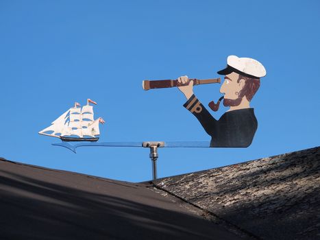 Marine weather vane shaped like a sailor blue sky background