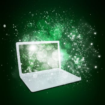 Open laptop with magic light and falling stars. Dark background