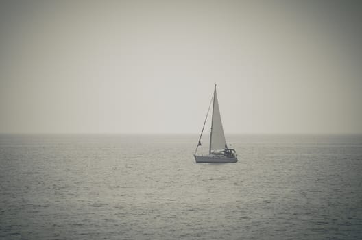 Retro style toned  photo of yacht sailing on the open sea