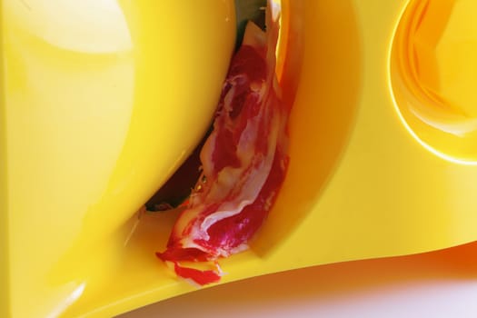 Bacon in yellow slicer, close up on the slice