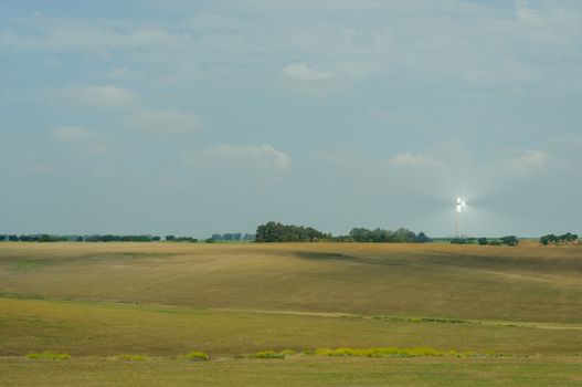 Tower of solar termal power plant, field and blue sky