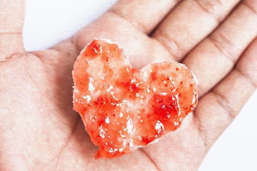 Bread heart with jam in man's hand