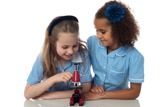 Smiling kids trying to learn use of microscope