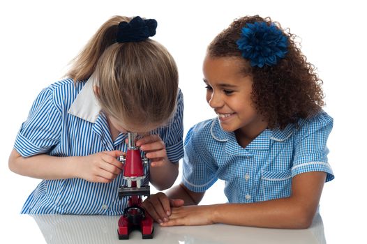 School girls using a microscope in lab