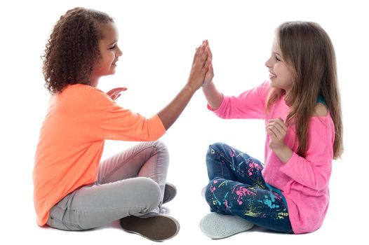 Pretty girls sitting on the floor and playing