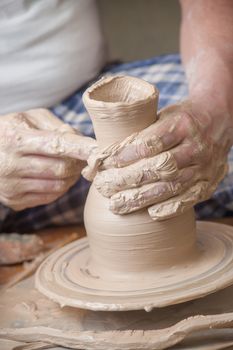 Hands of a potter, creating an earthen jar on the circle