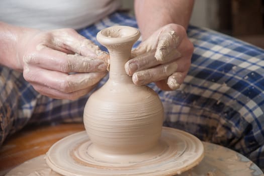 Hands of a potter, creating an earthen jar on the circle