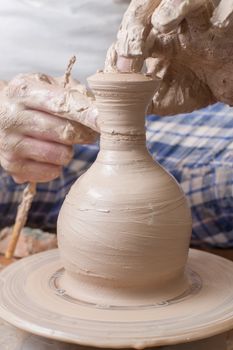 Hands of a potter, creating an earthen jar on the circle