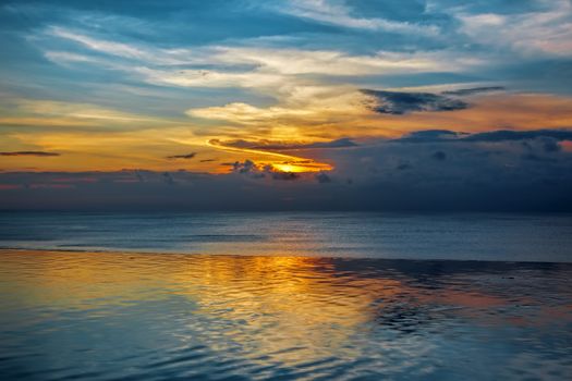 Balinese sunset with blue water and colorful skies