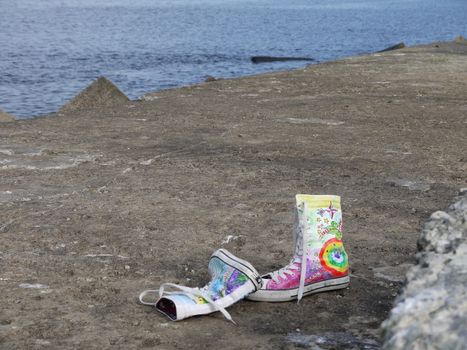 Pair of shoes on the ground at the sea