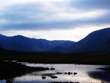 Scottish Highlands river in the mountains with blue sky