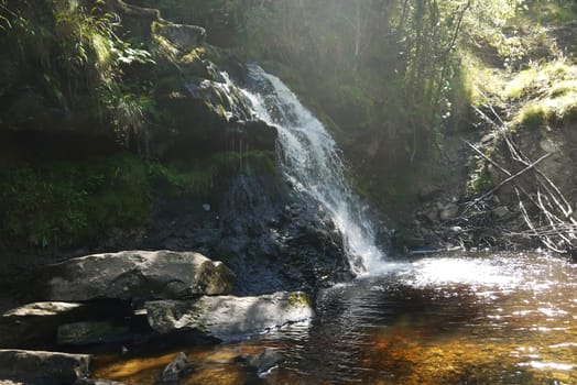 waterfall in forest river in scotland, UK