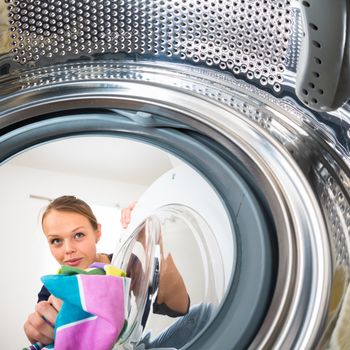 Housework: young woman doing laundry (shallow DOF; color toned image)