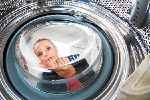 Housework: young woman doing laundry (shallow DOF; color toned image)