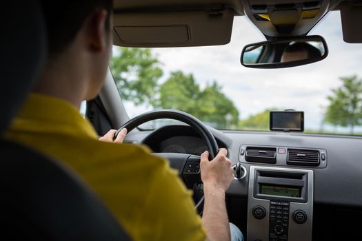 Man driving a car with his hands on the steering wheel