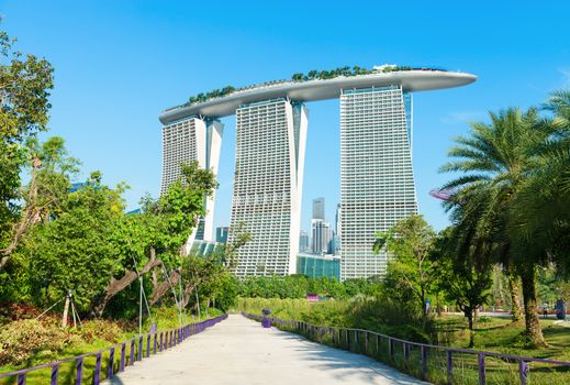 SINGAPORE - JUNE 01, 2013: Marina Bay Sands back view from Gardens by the Bay. Building was designed by architect Moshe Safdie and is adjacent to green Gardens by the Bay. 