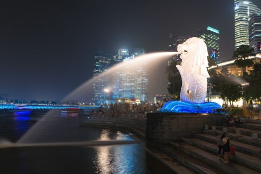 SINGAPORE -  DEC 31, 2013: The Merlion fountain and Marina Bay at night. Merlion is a mythical creature with the head of a lion and the body of a fish is a symbol of Singapore.