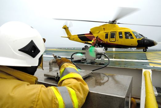 The helicopter landing officer are walking back after take care passenger to embark helicopter at oil rig platform is in the gulf of Thailand.