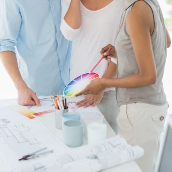 Interior designer showing colour wheel to client in her studio