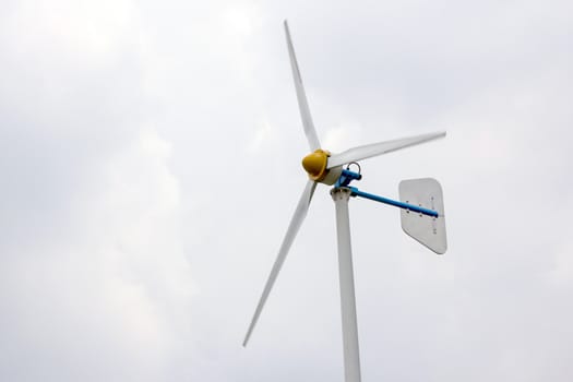 Wind turbine against cloudy sky