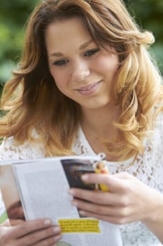 Teenage Girl Relaxing With Magazine Outdoors