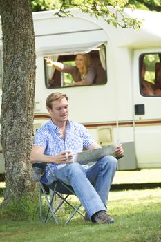 Man Relaxing Outside Mobile Home On Vacation