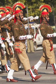 Soldiers in bright red and gold headdress parading down the Raj Path in preparation for the annual Republic Day Parade in New Delhi, India