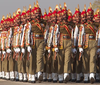 Soldiers in bright red and gold headdress parading down the Raj Path in preparation for the annual Republic Day Parade in New Delhi, India