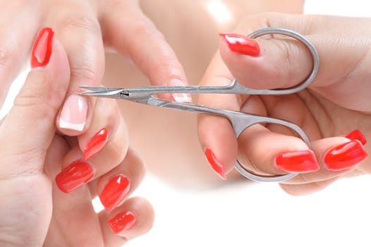 beauty salon, manicure applying, cutting the cuticle with scissors