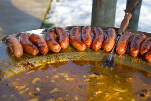 Baked sausages in traditional croatian dish kotlovina