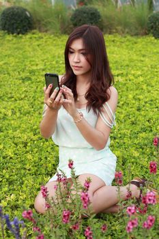 women playing mobile phone in the garden