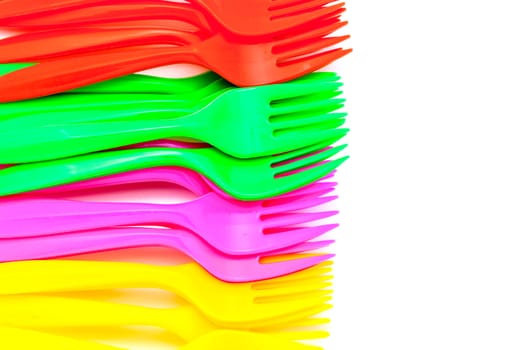 Multi colored plastic cutlery on a white background