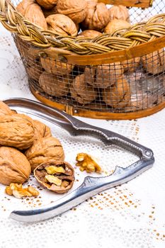 A composition of walnuts, cracked walnuts and a nutcraker