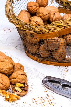 A composition of walnuts, cracked walnuts and a nutcraker