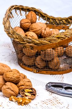 A composition of walnuts, cracked walnuts and a nutcraker