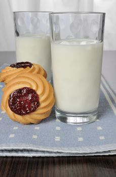 Glass of milk with biscuits with jam