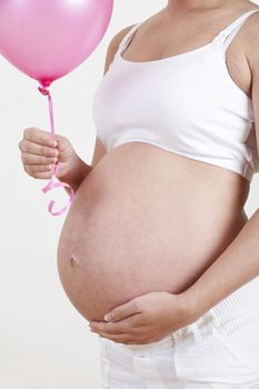 Close Up Of Pregnant Woman Holding Pink Balloon